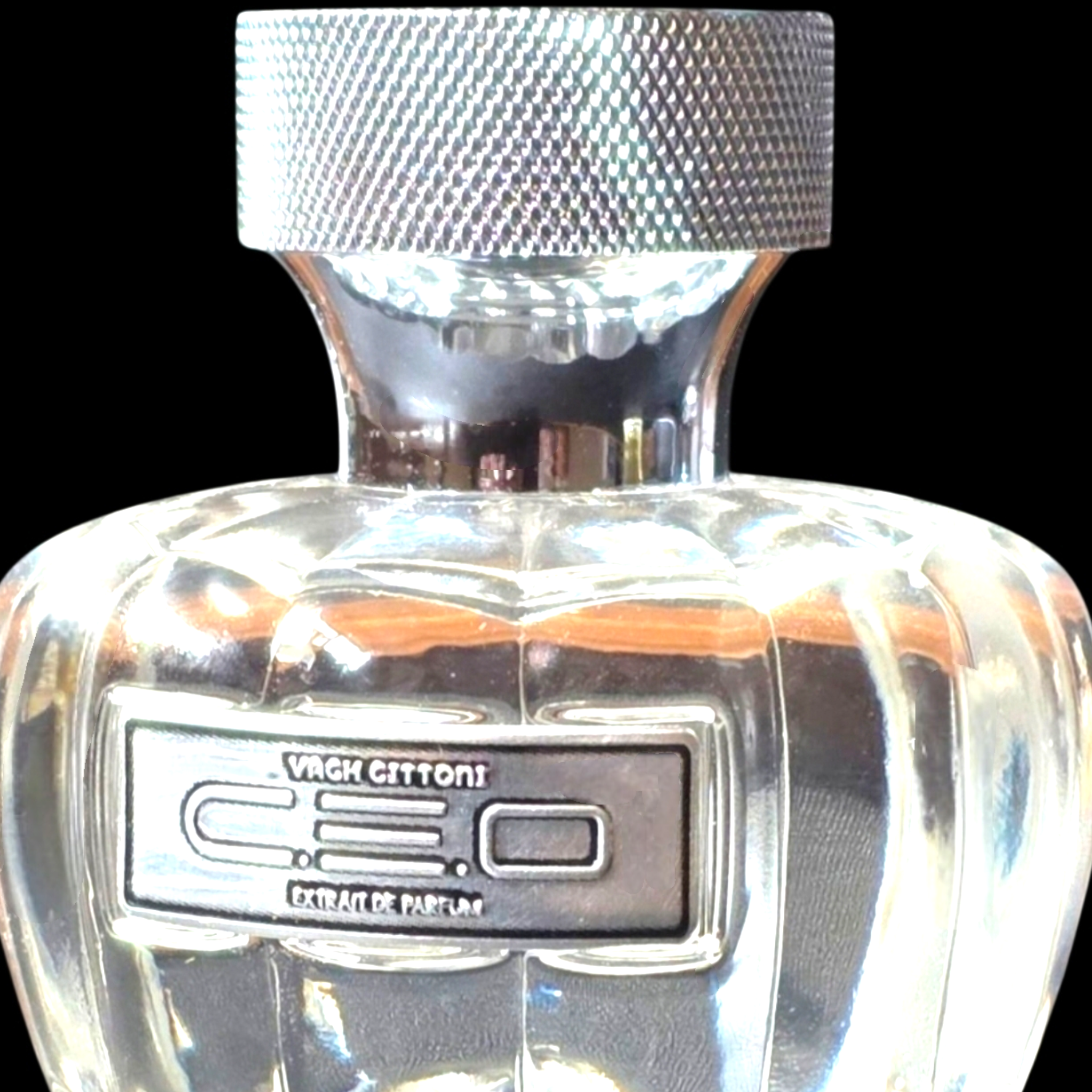 Clear perfume bottle with silver cap and visible brand logo on a black background